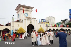 Turistas posan al frente del mercado de Ben Thanh, un emblema de Ciudad Ho Chi Minh. (Foto: VNA)