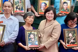 Van Thi Bach Tuyet, vicesecretaria del Comité del Partido Comunista de Vietnam en Ciudad Ho Chi Minh, entrega retratos restaurados de combatientes caídos a sus familiares. (Foto: Nhan Dan)