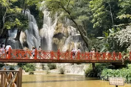 Turistas visitan la cascada de Kuang Si, uno de los destinos más emblemáticos de la provincia laosiana de Luang Prabang. (Foto: Le Duy Toan)