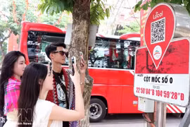 Los visitantes escanean un código QR en el marcador del kilómetro 0 de la provincia de Ha Giang para acceder a información turística. (Foto: VNA)