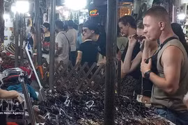 A los turistas internacionales les encanta comprar recuerdos en el mercado nocturno del Barrio Antiguo de Hanói. (Foto: VNA)
