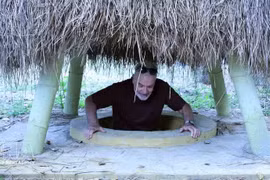 El turista se sitúa en una entrada de túnel ubicada en el jardín de una vivienda en el túnel de Ky Anh. (Foto: VNA)