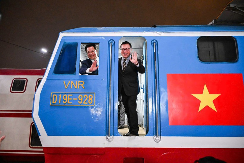El presidente editor del periódico Nhan Dan, Le Quoc Minh, y Dang Sy Manh, presidente del Consejo de Miembros de la Corporación de Ferrocarriles de Vietnam, en el “Tren de la Felicidad” la Nochevieja Lunar.
