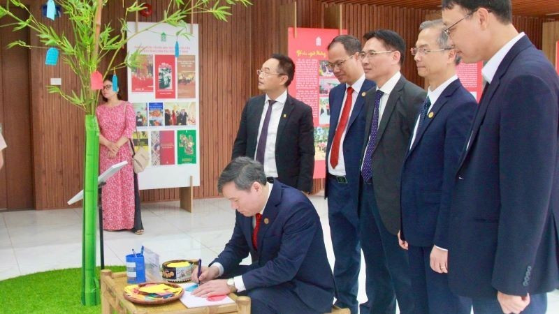 El profesor y doctor Le Van Loi, presidente de la Academia de Ciencias Sociales de Vietnam, plasma sus deseos de Año Nuevo en el espacio expositivo dedicado al árbol Neu, símbolo tradicional del pueblo vietnamita que representa un año nuevo de paz y bienestar.
