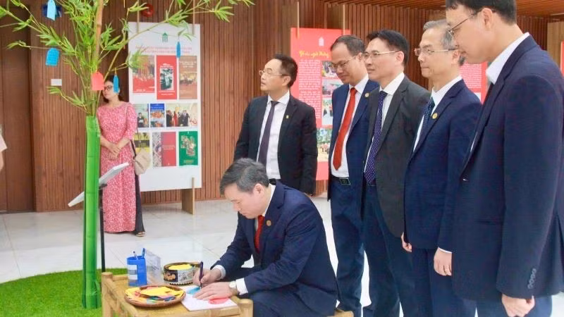 El profesor y doctor Le Van Loi, presidente de la Academia de Ciencias Sociales de Vietnam, plasma sus deseos de Año Nuevo en el espacio expositivo dedicado al árbol Neu, símbolo tradicional del pueblo vietnamita que representa un año nuevo de paz y bienestar.