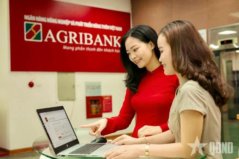 Empleados del Banco de Desarrollo Agrícola y Rural de Vietnam (Agribank) orientan a sus clientes sobre cómo realizar transacciones seguras en canales digitales. (Foto: qdnd.vn)