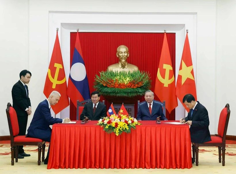 El secretario general del PCV, To Lam, y el secretario general del PPRL y presidente de Laos, Thongloun Sisoulith, presencian la firma de documentos de cooperación entre los dos países (Foto: VNA)
