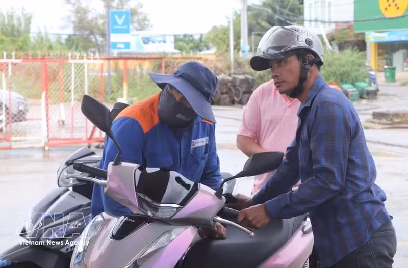 Los consumidores llenan sus tanques con la gasolina biológica E10 en una estación. (Foto: VNA)