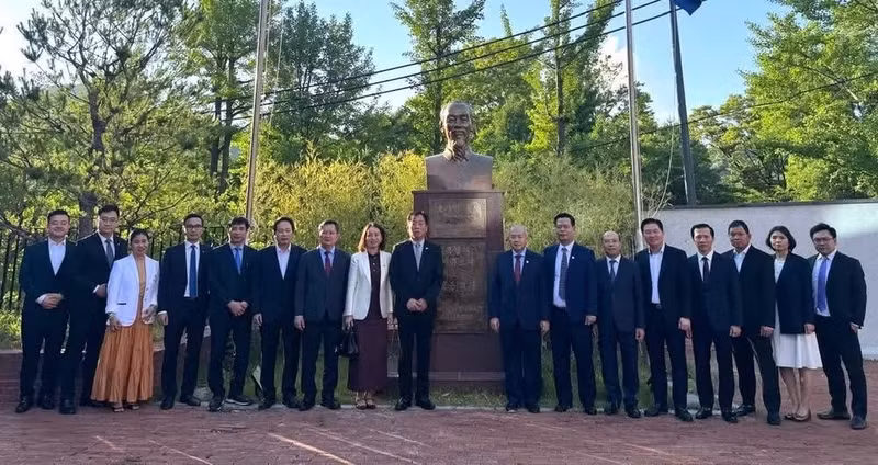 Personal de la embajada y la delegación de Hai Phong posan junto a la estatua del Presidente Ho Chi Minh en la sede de la misión diplomática vietnamita.