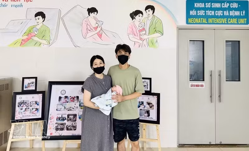 La pareja de turistas de Singapur junto a su bebé el día del alta hospitalaria. (Foto: VNA)