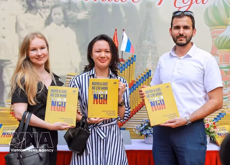 Espectadores con el libro bilingüe vietnamita-ruso “Nguyen Ai Quoc - Ho Chi Minh y Rusia”. (Foto: VNA)