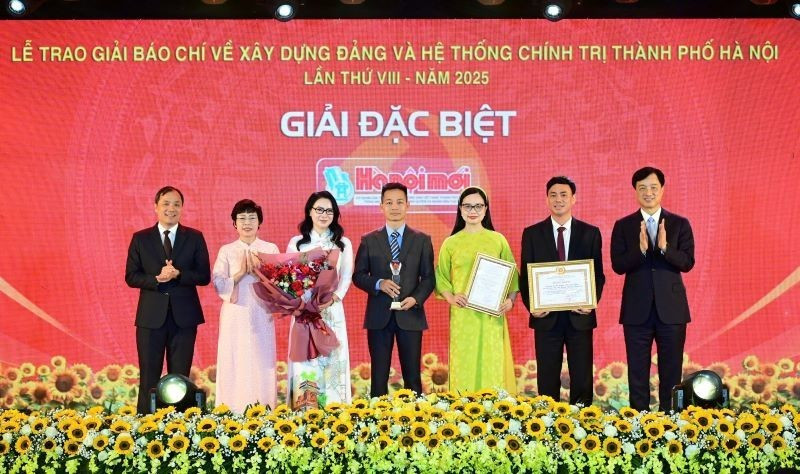 Nguyen Duy Ngoc, secretario del Comité del PCV en Hanói, y Hoang Trung Dung, subjefe permanente de la Comisión de Organización del Comité Central del Partido, entregan el Premio Especial a autores del periódico Hanoimoi.
