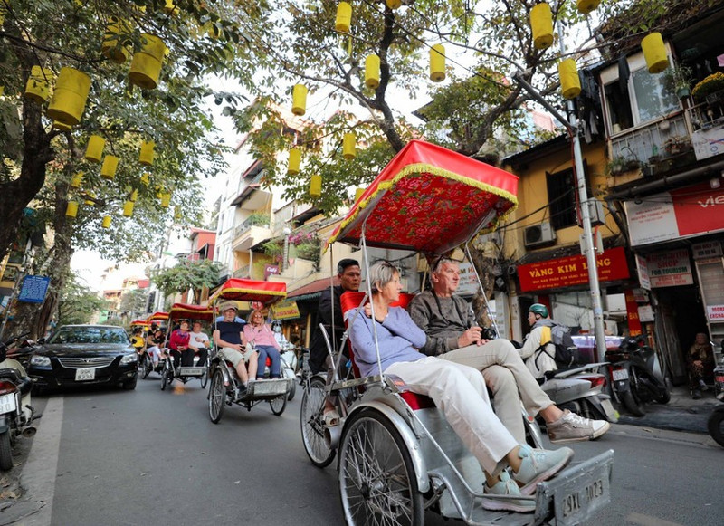Turistas extranjeros disfrutan de la belleza ancestral del Casco Antiguo de Hanói en ciclo. (Foto: VNA)