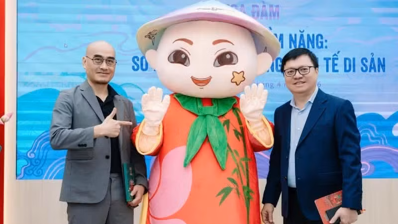 Le Quoc Minh, miembro del Comité Central del Partido Comunista de Vietnam, presidente-editor del periódico Nhan Dan, subjefe de la Comisión de Propaganda y Movilización de Masas del Comité Central y presidente de la Asociación de Periodistas de Vietnam, y Dao Trong Huy, presidente de AnnGroup, posan junto a la demostración de la mascota Anh Tre durante el seminario “Desatar el potencial: Propiedad intelectual en la economía patrimonial”, celebrado en el marco de las actividades conmemorativas del Día Mundial de la Propiedad Intelectual 2026.