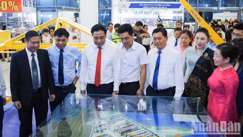 Nguyen Khac Toan, subsecretario permanente del Comité del Partido de Da Nang, (tercero a la izquierda), y los delegados visitan el stand del puerto de Da Nang.