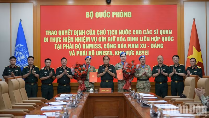 El teniente general Phung Si Tan, subjefe del Estado Mayor General del Ejército Popular de Vietnam, entrega as decisiones del Presidente de la República a dos oficiales del Ejército Popular de Vietnam que participarán en las operaciones de mantenimiento de la paz de las Naciones Unidas en Sudán del Sur y la región de Abyei. (Foto: VNA)
