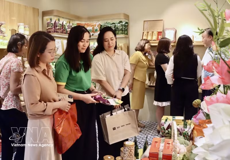 Visitantes en una exposición de productos promocionados en plataformas de redes sociales. (Foto: VNA)
