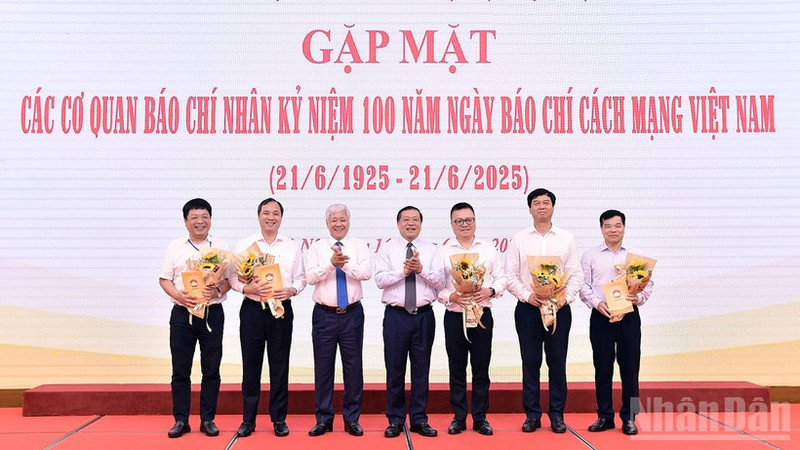 El presidente del Comité Central del Frente de la Patria de Vietnam, Do Van Chien y el subjefe de su Comisión de Propaganda y Movilización de Masas del Partido, Lai Xuan Mon (3º y 4º a la izquierda) entregan flores a los representantes los medios en el evento.