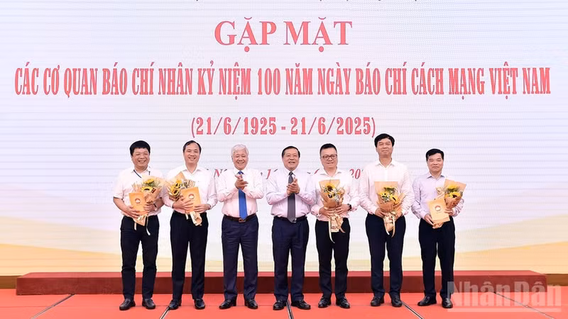 El presidente del Comité Central del Frente de la Patria de Vietnam, Do Van Chien y el subjefe de su Comisión de Propaganda y Movilización de Masas del Partido, Lai Xuan Mon (3º y 4º a la izquierda) entregan flores a los representantes los medios en el evento.