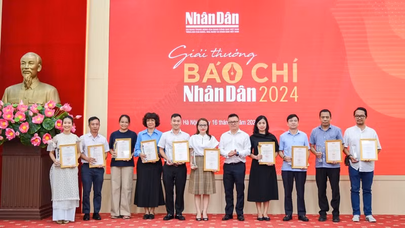 Le Quoc Minh, presidente-editor del periódico Nhan Dan, entrega el premio A a los autores y representantes de los grupos de autores. (Foto: THE DAI)
