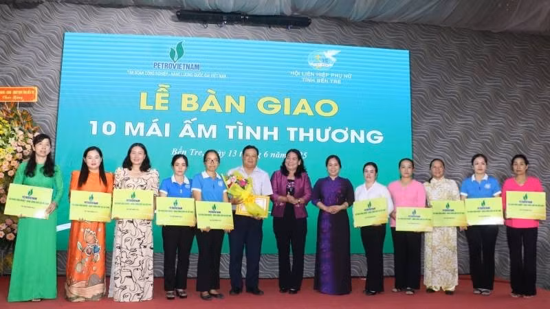 Una representante del periódico Nhan Dan entrega una placa simbólica de diez casas de caridad a las mujeres en situación difícil de la localidad. (Foto: HOANG TRUNG)