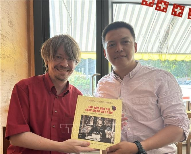 Massimiliano Ay, secretario general del Partido Comunista de Suiza, posa una foto con reportero de la VNA (Foto: VNA)