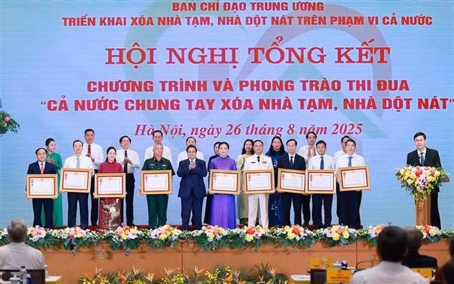 El primer ministro Pham Minh Chinh entrega la Orden del Trabajo de tercera clase a colectivos con logros destacados en el programa "Todo el país se une para eliminar viviendas precarias" (Foto: VNA)