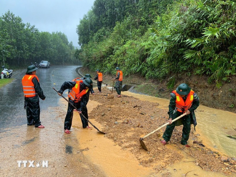 Guardias fronterizos de la ciudad de Hue excavan tierra y rocas para nivelar la carretera afectada por el deslizamiento de tierra en el paso de Pe Ke, en la comuna de A Luoi 1. (Foto: VNA)