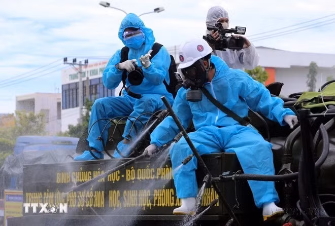Un reportero de la VNA trabaja desde la parte trasera de un camión rociando desinfectante en zonas de alto riesgo de la pandemia del COVID-19 en Son Tra, ciudad de Da Nang. (Foto: VNA)