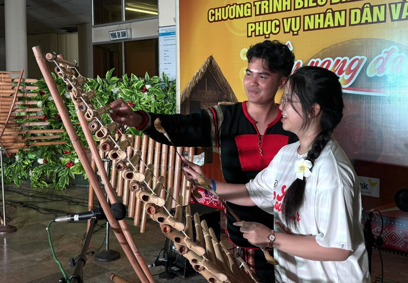 Una joven connacional experimenta el xilófono T'rung (Foto: VNA)