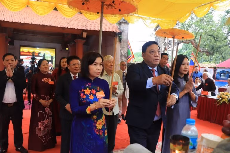 La vicepresidenta del Comité Popular de la provincia de Phu Tho, Phung Thi Kim Nga, y otros asistentes al acto ofrecen inciensos.