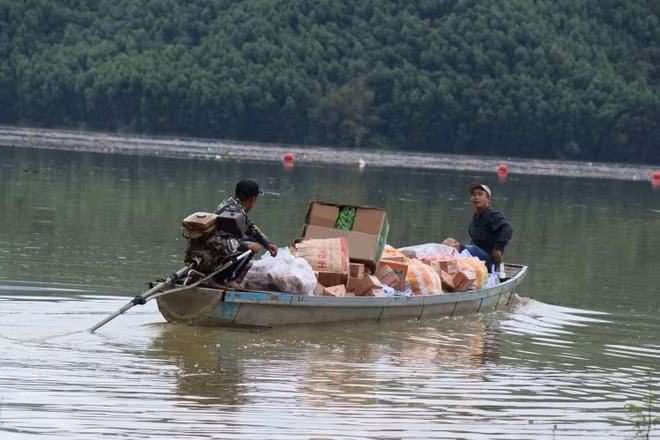 Las fuerzas funcionales utilizan lanchas motoras para transportar alimentos a las personas residentes en zonas aún aisladas por las inundaciones (Foto: VNA)
