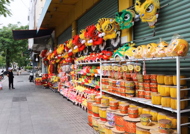 Se venden cabezas de león y productos relacionados con la festividad en la calle de Tran Hung Dao, barrio de Phu Xuan.