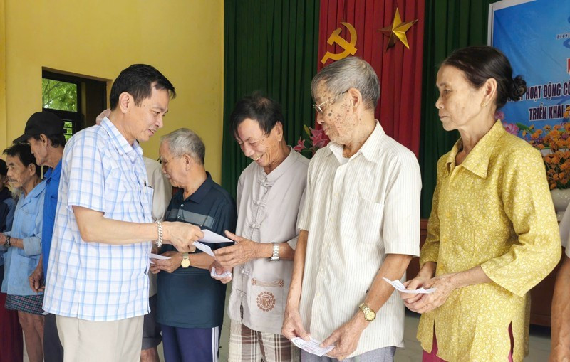 Un representante del periódico Nhan Dan en Quang Tri entrega donaciones en efectivo a los habitantes de la aldea de Hoi Ky, comuna de Nam Hai Lang.