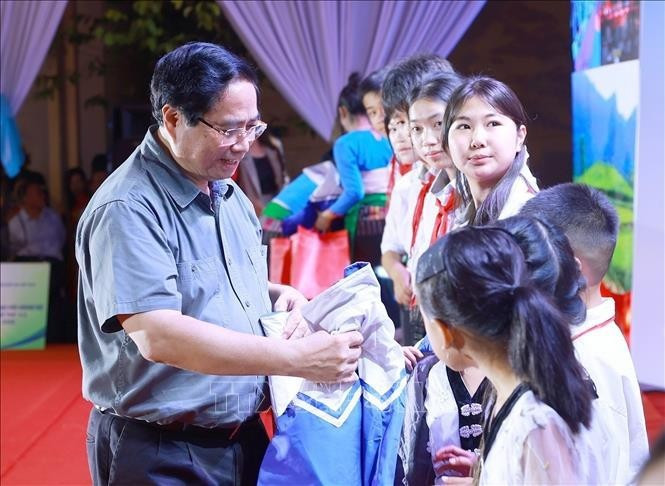 El primer ministro Pham Minh Chinh regala abrigos a los estudiantes de la comuna de Bat Mot. (Foto: VNA)