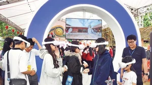 Los jóvenes exploran el festival de Co Loa y la antigua ciudadela de Co Loa en el espacio digital. (Foto: Nhan Dan)