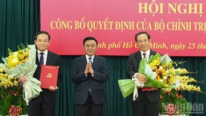 El miembro del Buró Político y permanente del Secretariado del Comité Central del PCV, Tran Cam Tu, entrega las decisiones del Buró Político a Tran Luu Quang y Nguyen Van Nen (Foto: Nhan Dan)