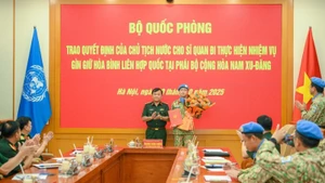 El miembro del Comité Central del Partido Comunista de Vietnam y viceministro de Defensa, teniente general Hoang Xuan Chien, entrega la decisión del Presidente de la República al oficial designado a una misión de mantenimiento de la paz de la Organización de las Naciones Unidas. (Foto: Nhan Dan)