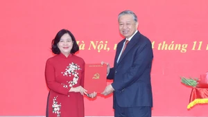 El secretario general del Partido Comunista de Vietnam, To Lam, entrega la decisión del Buró Político sobre la designación de la camarada Bui Thi Minh Hoai como secretaria del Comité del Partido del Frente de la Patria y las organizaciones de masas centrales para el mandato 2020-2025.