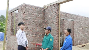 Un funcionario de la comuna de Viet Hong (provincia de Lao Cai) inspecciona la construcción de la casa de una familia local (Foto: VNA)