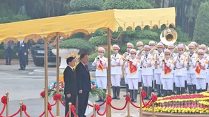 El secretario general del Partido Comunista de Vietnam (PCV), To Lam, y el secretario general del Partido Popular Revolucionario y presidente de Laos, Thongloun Sisoulith, se paran el podio de honor mientras se entonan los himnos de los dos países. (Foto: Nhan Dan)