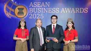 Teo Siong Seng, presidente del Consejo Asesor Empresarial de la Asean en Singapur (segundo a la izquierda), entrega el premio al representante de Vietjet. (Foto: Nhan Dan)