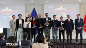 Los ponentes reciben obsequios del comité organizador. (Foto: VNA)