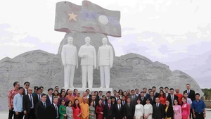 La delegación deposita flores ante las estatuas de los presidente Ho Chi Minh, Phomvihane y Souphanouvong en el Parque de la Amistad Laos-Vietnam, en Vientián. (Foto: Nhan Dan)