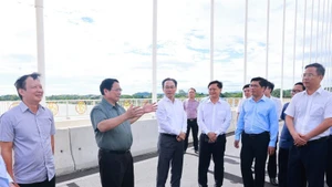 El primer ministro Pham Minh Chinh inspecciona el puente de Nguyen Hoang. (Foto: VNA)
