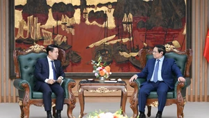El primer ministro vietnamita, Pham Minh Chinh, y Saleumxay Kommasith, viceprimer ministro y jefe de Comisión de Reforma de Empresas del Comité Central del PPRL. (Foto: Nhan Dan)