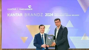 Le Hoang Tung, subdirector general de Vietcombank (izquierda), recibe el certificado de Sumit Kamra, director de desarrollo estratégico de Kantar Insights. (Foto: VNA)