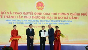 El viceprimer ministro Nguyen Hoa Binh (segundo desde derecha) presenta la decisión del primer ministro de establecer la Zona de Libre Comercio de Da Nang el 22 de junio. (Foto: VNA)