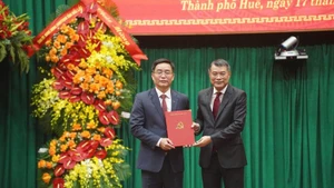 Le Minh Hung, miembro del Buró Político, secretario del Comité Central del PCV y jefe de su Comisión de Organización, felicita a Nguyen Dinh Trung (Foto: VGP)