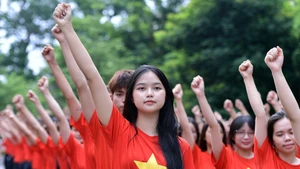 Jóvenes vietnamitas organizan simultáneamente ceremonia de saludo a la bandera 'Amo a mi Patria'. (Foto: Nhan Dan)